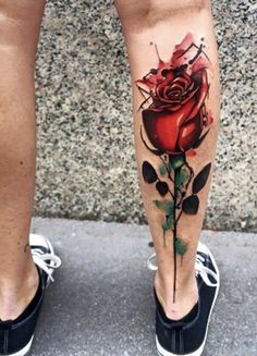 a woman's leg with a rose tattoo on it