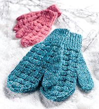 two knitted mittens sitting next to each other on top of snow covered ground