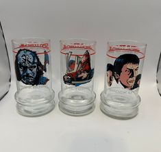 three glass cups with comic covers on them