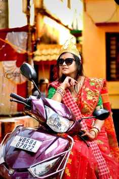 a woman sitting on the back of a purple scooter wearing a headdress