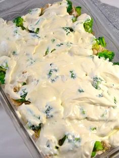 a casserole dish with broccoli and white sauce in it on a table