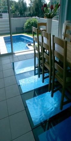 a dining room table and chairs near a swimming pool