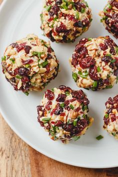 several cookies on a white plate with green onions and cranberry toppings in the middle