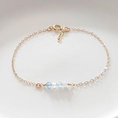 Dainty Aquamarine Bracelet, Aquamarine March Birthstone Bracelet, Delicate Gold Bracelet, 14K Gold Filled, 925 Sterling Silver, 14K Gold Filled ------------------- Genuine Aquamarine gemstone beads completed with a dainty, minimalist, simple chain in 925 sterling silver, 14K gold filled or 14K rose gold filled. Gorgeous dainty bracelet that would make a unique gift. Aquamarine is the March birthstone. Choose your stone by meaning or color, we have birthstones for every month.  * Gemstones: 2mm, 3mm * Gemstone bar: 1 inch long * Chain - Cable chain   * Material - 14K Rose gold filled, 14K Gold filled, 925 Sterling silver * These are natural stones therefore colors may slightly vary. ADD A DISC ----------------- https://www.etsy.com/uk/listing/737519880/925-sterling-silver-add-personalized?c Delicate Gold Bracelet, Month Gemstones, Aquamarine Bracelet, Simple Chain, Birthstone Bracelet, Dainty Bracelet, March Birthstone, Birthstone Bracelets, Dainty Bracelets