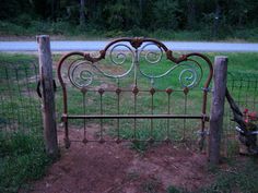 an iron bed frame in the middle of a field