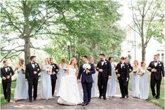 a bride and groom walking with their wedding party