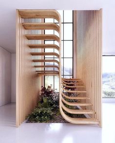 a spiral staircase in the middle of a room with plants on the floor and large windows