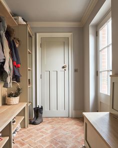 a walk in closet with brick flooring and white doors, shoes on the shelf