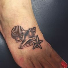 a foot with a starfish and seashell tattoo on it