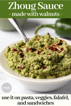 a white bowl filled with pesto sauce on top of a table