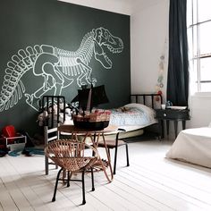 a child's room decorated in black and white with dinosaur stencils on the wall