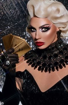 a woman in black and white makeup holding a fan