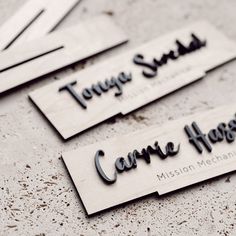 four wooden name tags sitting on top of a cement floor