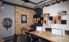 an office with brick walls and wooden desks, computer screens on the wall, and open shelves