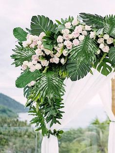 an outdoor wedding setup with white flowers and greenery