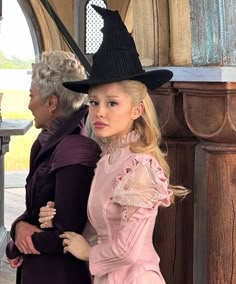 two women standing next to each other wearing hats