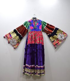 A beautiful Handmade Tribal Kutchi Dress from Afghanistan. Embellished with detailed beading and embroidery this dress has a rich velvet embellished skirt with gold and silver lame, mirrors, beading and embroidery. Kutchi embroidery has approximately 16 different types of stitches and styles and it is these variations that allow for the differentiation between the communities. Embroidery techniques are passed down from mother to daughter. The traditional dress of Afghanistan was very tremendous Bollywood Style Hand-embellished Dresses For Festivals, Fitted Velvet Bollywood Dress, Floor-length Sequin Dresses For Festivals, Festive Traditional Embroidered Dress, Festive Velvet Embroidered Dress, Festive Embroidered Velvet Dress, Traditional Dresses With Multicolor Embroidery And Sequins, Traditional Embroidered Dress With Sequins, Traditional Embroidered Sequin Dress