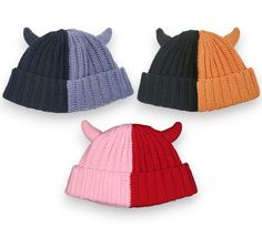 three knitted hats with horns are shown in different colors and sizes on a white background