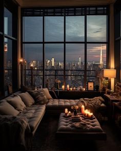 a living room filled with lots of furniture next to large windows and candles on the coffee table