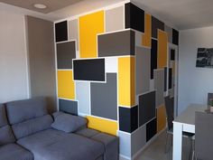 a living room filled with furniture and walls painted in different shades of grey, yellow and black