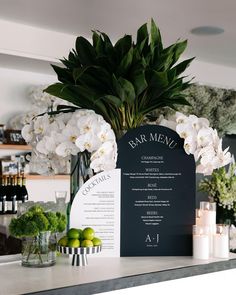 the bar is decorated with white flowers and greenery