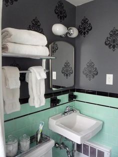 a white sink sitting under a bathroom mirror next to a towel dispenser