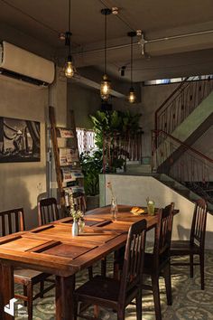 a dining room table and chairs in front of stairs