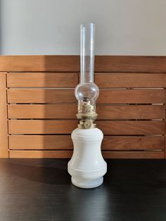 a white lamp sitting on top of a wooden table