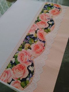 an image of a table runner with roses on it and lace trimming around the edge