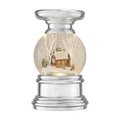 a snow globe with a small house in the middle and trees around it, on a white background