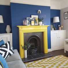 a living room with a yellow fireplace and blue walls