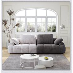 a grey and white couch sitting in a living room next to a large round window