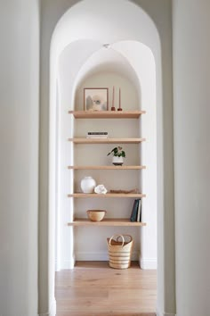 an archway leading into a room with shelves and baskets