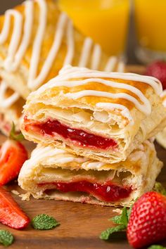 strawberry turnover sandwiches stacked on top of each other with strawberries and orange juice in the background