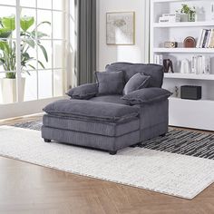 a living room with a couch, chair and bookshelf on the floor in front of a window