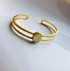 A piece of stylish & modern look gold bangle, which is made with genuine 100% natural real light green Chinese jade bead and 14k gold plated 925 sterling silver bracelet. A great combination of charm and elegance. The minimalistic design is great for your daily wear or special occasions. Perfect as a gift for your loved ones or just as a treat yourself :) Some Highlights of this gold jade bead cuff are: ＊High-quality Material Only 100% natural green jades paired with solid 925 sterling silve Modern Yellow Gold Jade Jewelry, Modern Oval Jade Jewelry, Modern Adjustable Oval Bangle, Jade Bangle Jewelry For Gifts, Jade Bangle Jewelry Gift, Elegant Adjustable Jade Jewelry, Modern Green Cuff Bangle Bracelet, Modern Green Bangle Jewelry, Adjustable Oval Modern Cuff Bracelet