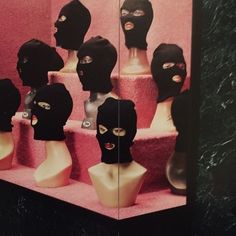 there are many mannequins with black masks on them in front of a mirror