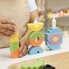 a woman is playing with wooden toys on the table in front of other toy items