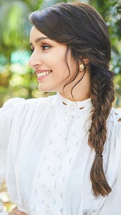 a woman with long hair wearing a white blouse