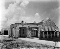 an old brick building with arched windows on the front and side of it is shown in black and white