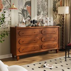 a dresser with many items on it in front of a large window and wallpaper