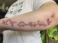 a man with a tattoo on his arm that has different types of dinosaurs in it