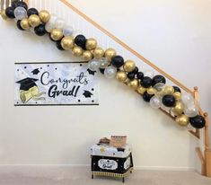 a staircase decorated with black, white and gold balloons for graduation party decorations on the wall