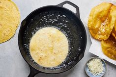 an iron skillet filled with food next to some tortilla chips on a table