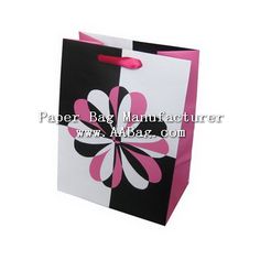 a black and white shopping bag with pink flowers on the front, sitting against a white background