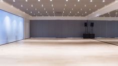 an empty room with speakers and lights on the ceiling