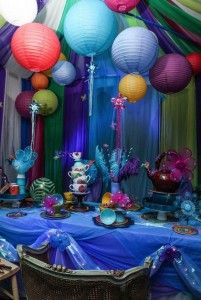 a table topped with lots of different colored paper lanterns and plates on top of it