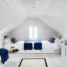 a bedroom with two beds and white walls