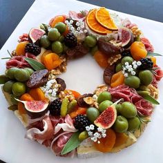 a white plate topped with a fruit and veggie wreath on top of a table