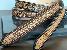 two brown and black belts sitting on top of a table